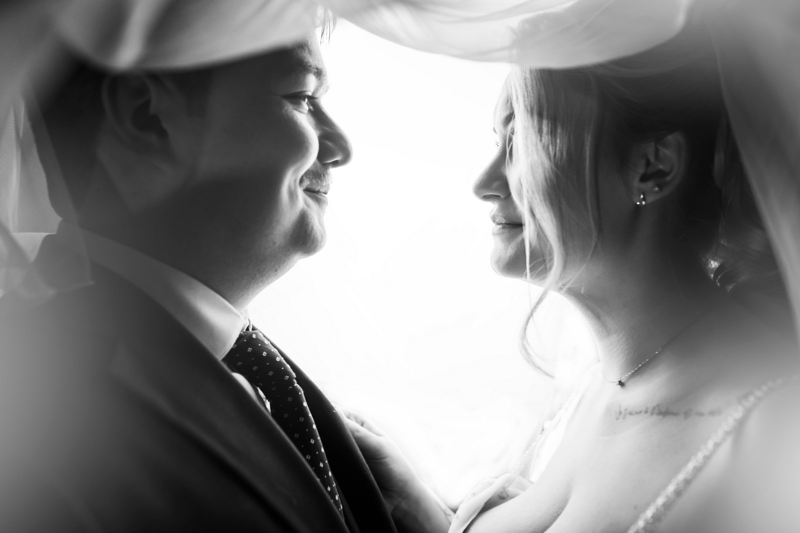 Couple de mariés se regardant profondément, photo en noir et blanc prise dans un studio temporaire monté sur le lieu de leur mariage à Paris